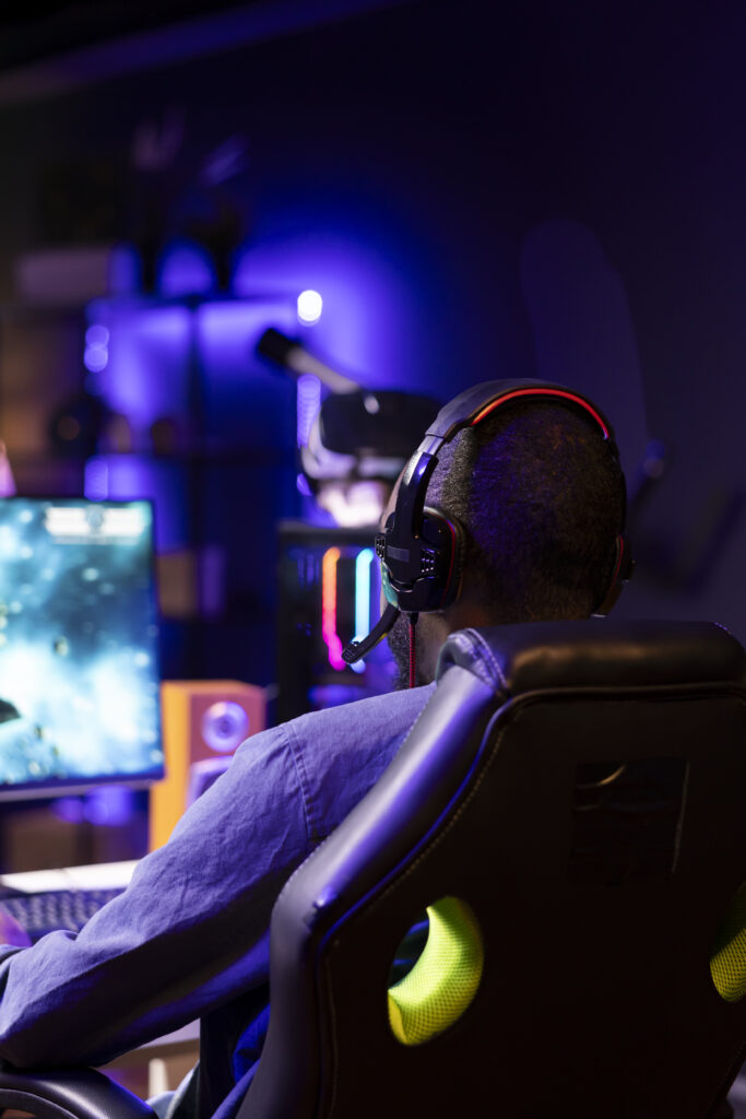 Gamer using headphones to discuss with mates while playing online SF videogame